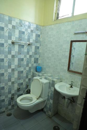 a bathroom with a toilet and a sink at Hotel Shri Bhaskar in Bareilly