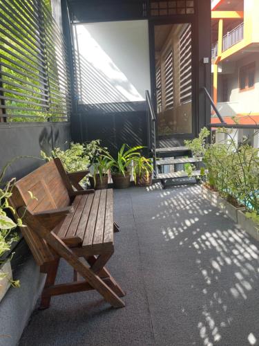 a wooden bench sitting on a patio with plants at Airport waterfront chalet in Katunayake