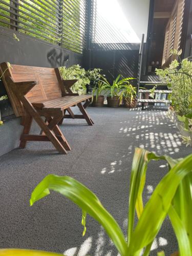 a wooden bench sitting on a patio with plants at Airport waterfront chalet in Katunayake