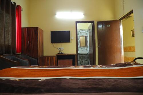 a hotel room with a bed and a television at Hotel Shri Bhaskar in Bareilly
