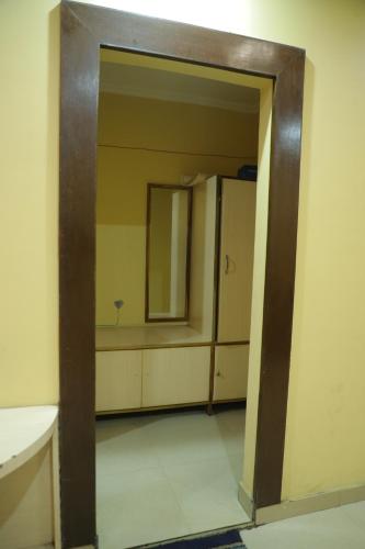 an open door to a bathroom with a mirror at Hotel Shri Bhaskar in Bareilly