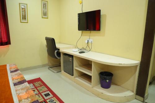 a room with a desk with a tv on a wall at Hotel Shri Bhaskar in Bareilly