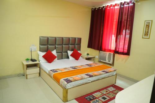 a bedroom with a bed with red pillows at Hotel Shri Bhaskar in Bareilly