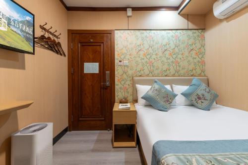 a hotel room with two beds and a door at East Sacred Hotel-Very close to the Drum Tower,The Lama Temple,Houhai Bar Street,Nanluoguxiang,Tiananmen Square and the Forbidden City, and the subway st ation is also very close in Beijing