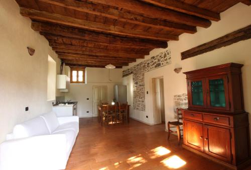 salon z białą kanapą i drewnianym sufitem w obiekcie Country House Cozzena w mieście Maslianico