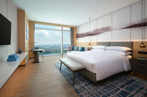 a bedroom with a large bed and a large window at Courtyard by Marriott Guangzhou Pazhou in Guangzhou