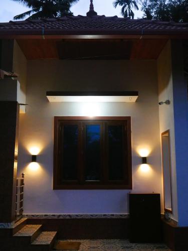 a house with two lights on the side of it at Suvi Homestay - Coorg in Ammatti