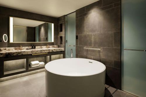 a bathroom with a tub and a mirror at THE OSAKA STATION HOTEL, Autograph Collection in Osaka
