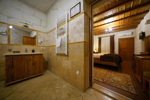 a bathroom with a sink and a room with a bed at Harman Cave Hotel in Goreme