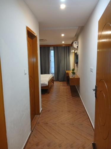 a hallway of a hotel room with a bed and a door at Grande apartments 205,206 in Rawalpindi