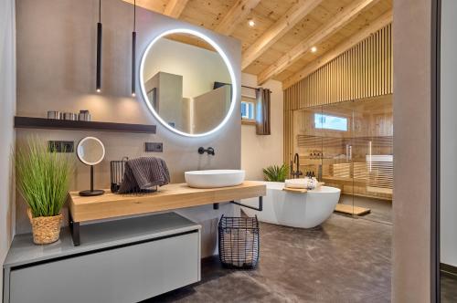 a bathroom with a large mirror and a tub at Luxus Chalet Zur Resi in Mauth