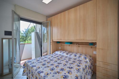 a bedroom with a bed and a sliding glass door at Oasi 55 in Lido di Spina