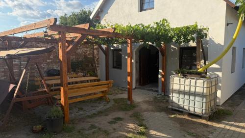 a pergola with a wooden bench and a building at Ubytování U Kocábů in Drnholec