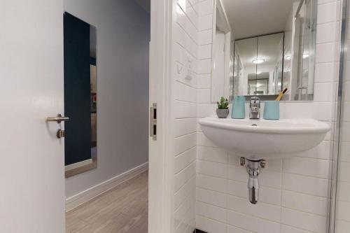 ein Badezimmer mit Waschbecken und Spiegel in der Unterkunft Student Only Bronze Studio Plus at Hammersmith Residence in London