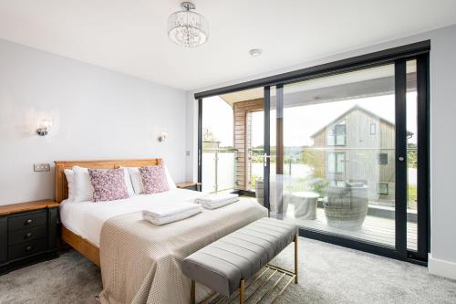 a bedroom with a bed and a large window at Howard Lodge BV27 Silverlake Dorset in Warmwell
