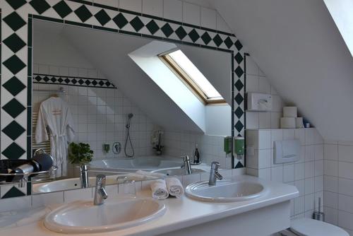 a bathroom with three sinks and a large mirror at Thermenhotel Vier Jahreszeiten in Lutzmannsburg