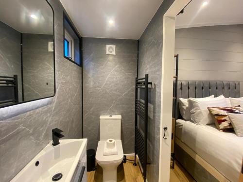 Un baño con lavabo, inodoro y una cama. en P59 - Riverstone with hot tub, en Bethesda