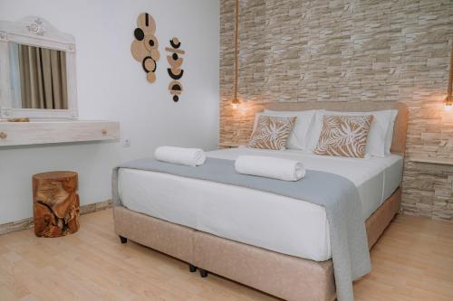 AsgourouにあるDimosthenis Land - Private Luxury Stayのレンガの壁のある部屋にある大きなベッド