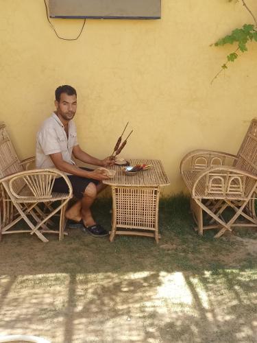 a man sitting on a chair next to a table at Saqqara tent in Cairo