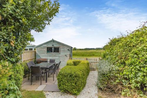 a garden with a table and chairs and a shed at 3 Bed in Baconsthorpe oc-s32338 in Baconsthorpe