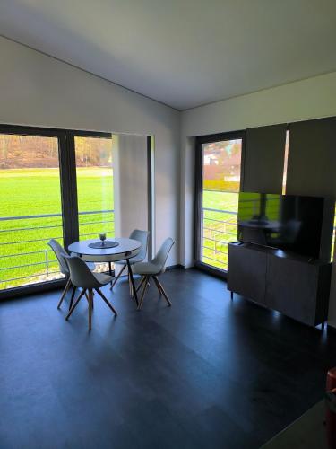 a living room with a table and chairs and a television at Stadt und See Nahes Appartment in Klagenfurt