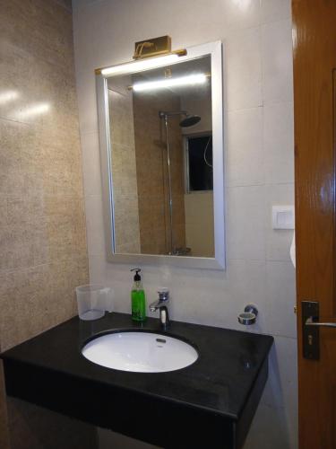 a bathroom with a sink and a mirror at Grande apartments 205,206 in Rawalpindi