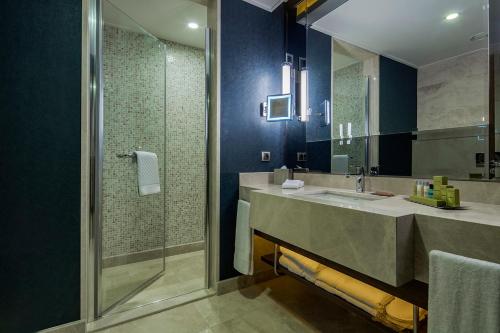a bathroom with a large sink and a shower at Doubletree By Hilton Istanbul Topkapi in Istanbul