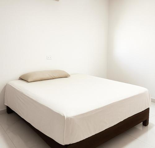 een bed in een slaapkamer met een witte muur bij Departamento Puerto Vallarta in Puerto Vallarta