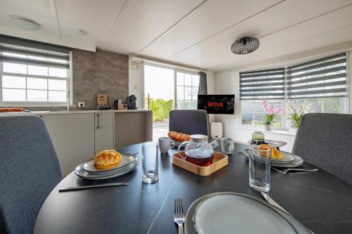 a dining room with a black table and chairs at 88, Renovated July '25 - In The Woods - AC - Parking in Oisterwijk