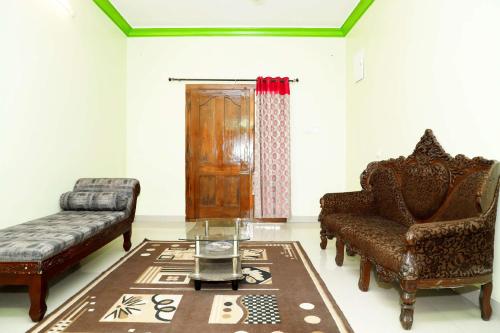 a living room with two chairs and a table at Cozy Heaven in Ooty