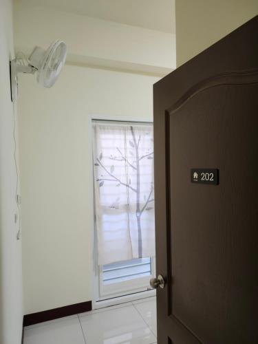 a door with a window in a room with a tree at 谷香 Guxiang House 東區靜巷透天獨棟 in Tainan