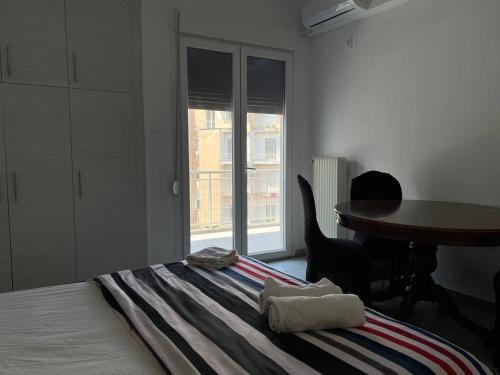 a bedroom with a bed with a table and a window at Kipseli Rooms in Athens