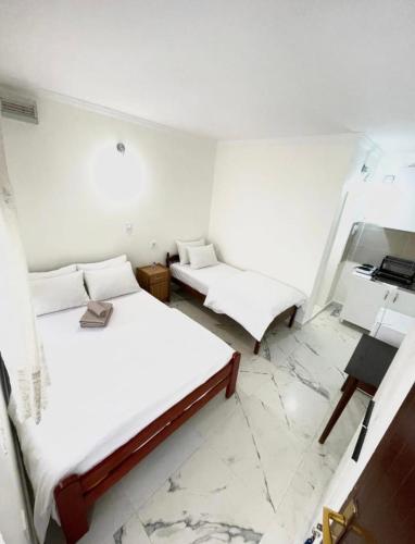 two beds in a room with white walls at Jasmine Apartment in Rafailovici