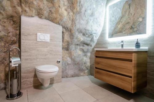 a bathroom with a toilet and a sink at Villa Castella Verde in Rogoznica