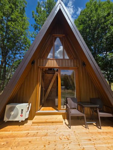 Una casa pequeña con una ventana grande y un ventilador. en Tišina, en Duži