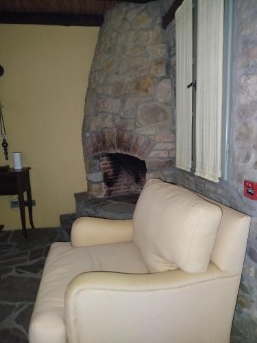 a white couch in front of a stone fireplace at Volissos Sea View Maisonettes in Volissos