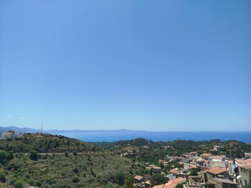 a town on a hill with the ocean in the background at Volissos Sea View Maisonettes in Volissos