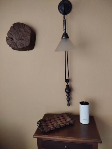 a table with a lamp on a wall and a table with a lamp at Volissos Sea View Maisonettes in Volissos