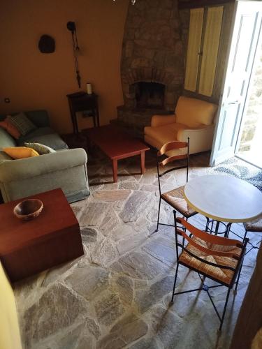a living room with a couch and a table and chairs at Volissos Sea View Maisonettes in Volissos