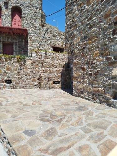 a stone patio in front of a stone building at Volissos Sea View Maisonettes in Volissos