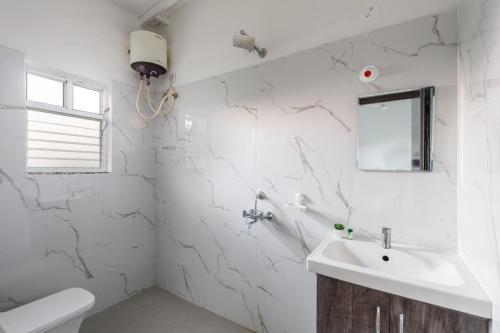 GūdūrにあるThe Farmstays JF PoolBasketball Courtの洗面台とトイレを備えた白いバスルーム