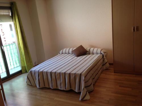 a bedroom with a bed with a striped blanket at SM Apartments in Lleida