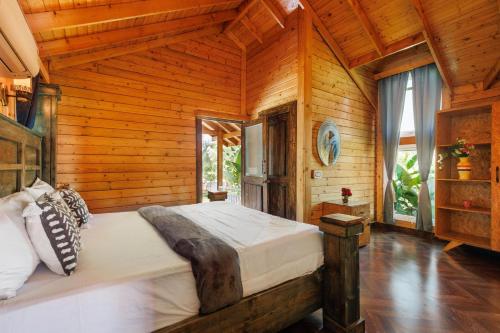 a bedroom with a large bed in a wooden room at The Farmstays CHRPoolGlass RoomsACWi-FiLawn in Hyderabad