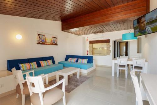 a living room with a couch and a table and chairs at 3HB Golden Beach in Albufeira