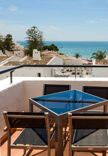 a table and chairs on a balcony with a view of the ocean at 3HB Golden Beach in Albufeira