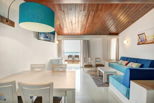 a living room with a blue couch and a table at 3HB Golden Beach in Albufeira