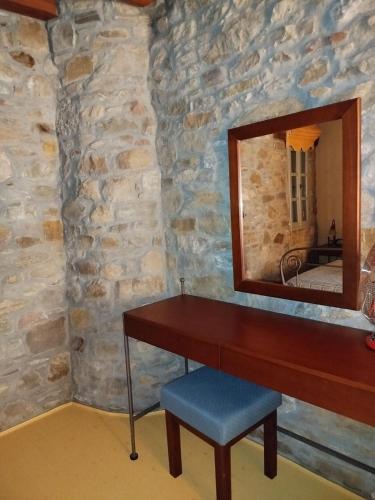 a dressing table with a mirror and a stool at Volissos Sea View Maisonettes in Volissos