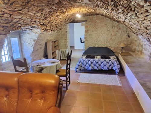 a room with a bed and a table and chairs at Le Relais Provençal in Barret-de-Lioure