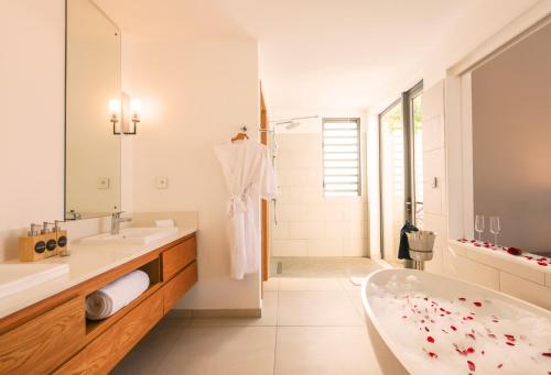a white bathroom with a tub and a sink at Mythic Suites & Villas by MJ Holidays in Grand Gaube
