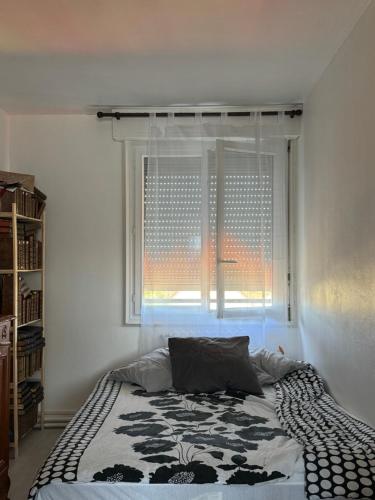 une chambre avec un lit et une fenêtre avec un habillage de fenêtre dans l'établissement 24 H Circuit Le Mans, au Mans